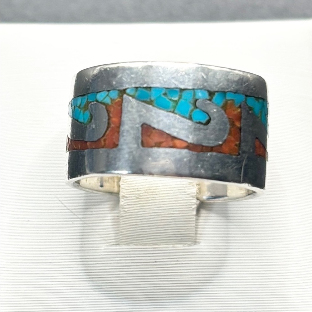 A Navajo Sterling Silver band ring with Coral and Turquoise inlay. Tested